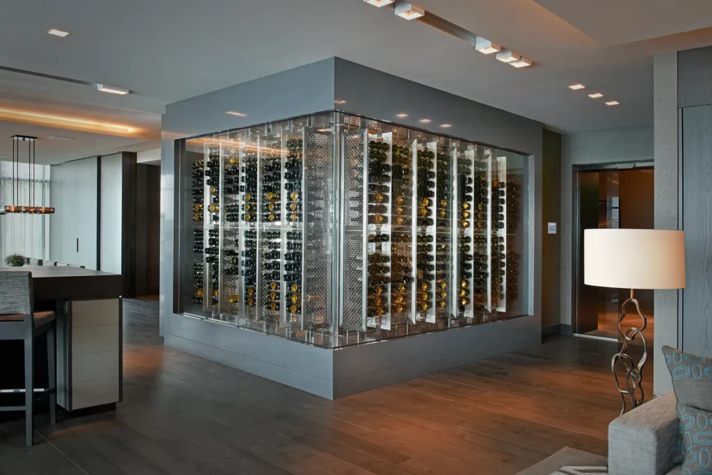 The glass-enclosed bottle display in the Regalia Wine Room sits near a kitchen area with wooden floors