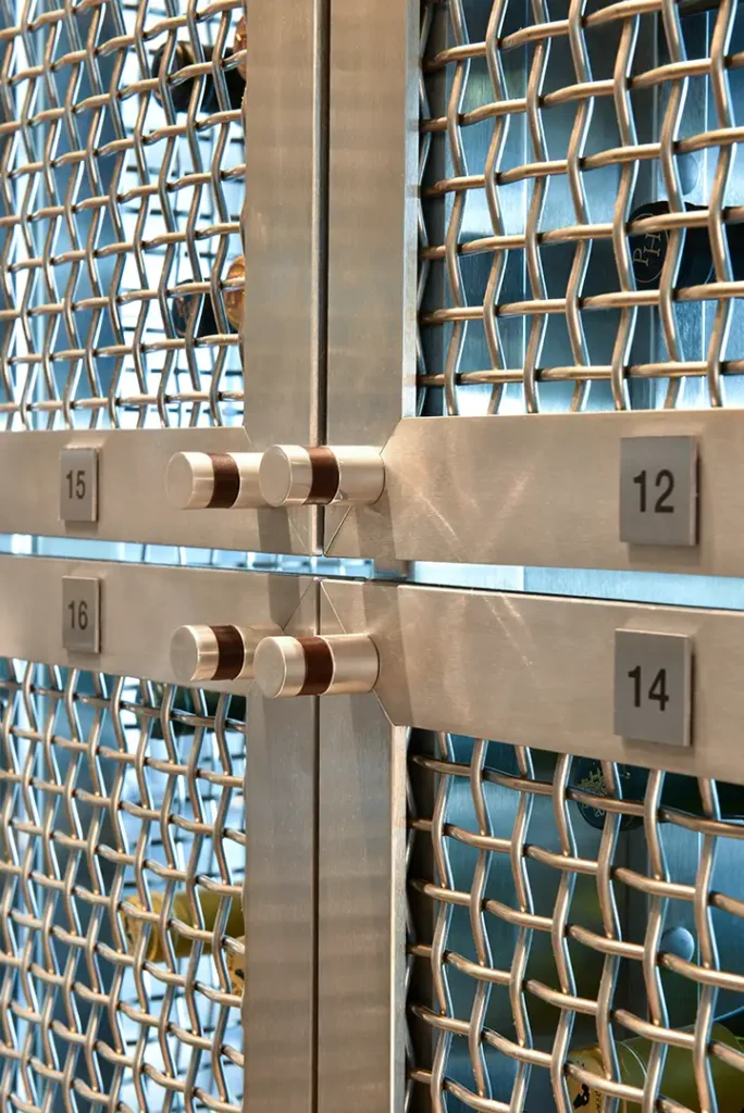 Metal mesh shelving with numbered panels and wine bottles in the Regalia Wine Room