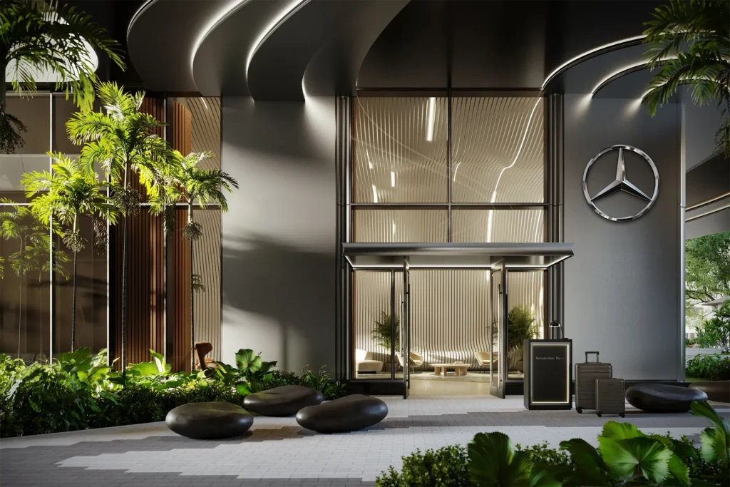 En la fachada oscura de la entrada de Mercedes-Benz Places, junto a la vegetación tropical, destaca un gran logotipo de Mercedes-Benz.