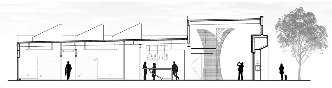 Una vista arquitectónica de un edificio alargado con tejado en forma de diente de sierra, varias personas y un árbol grande a la derecha