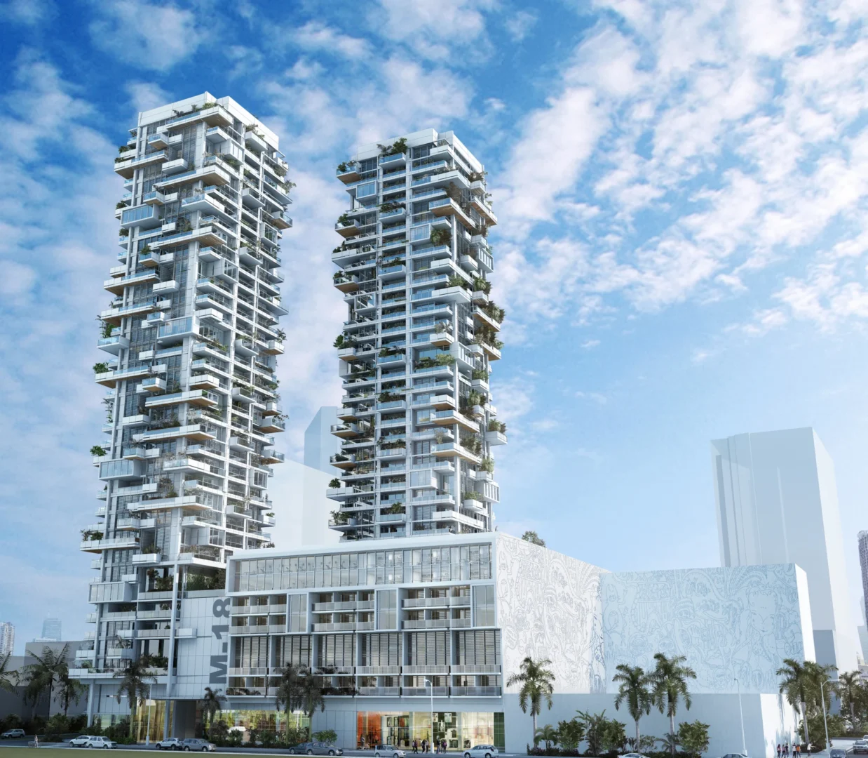 Two white towers for Miami 18 feature staggered balconies with greenery above a large building base under a cloudy sky