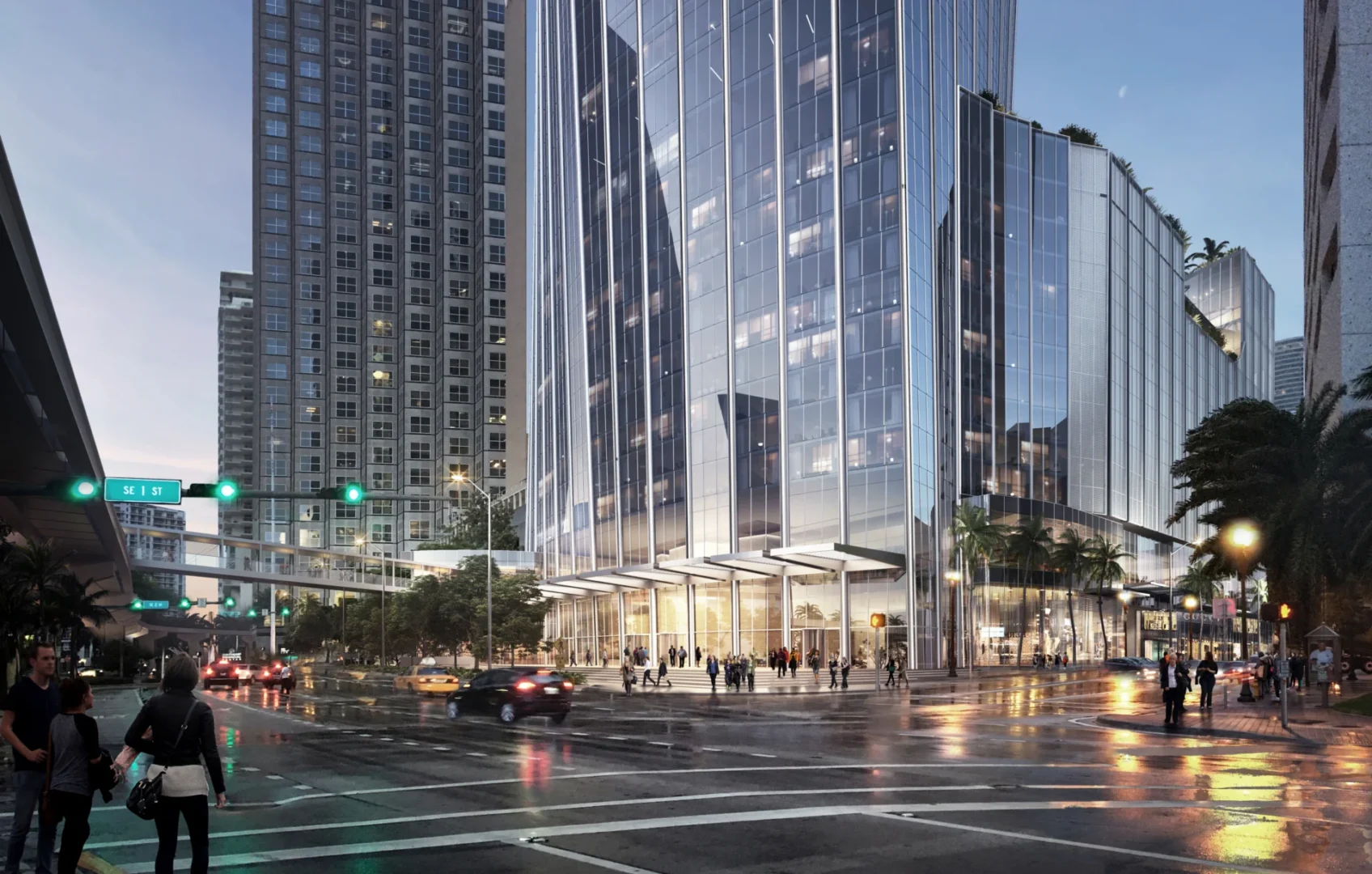 Glass skyscrapers of One Bayfront Plaza rise above an intersection with cars, pedestrians, and streetlights on wet streets