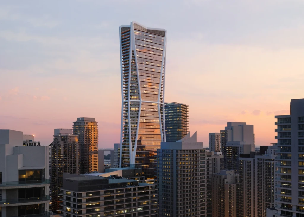 Un rascacielos de gran altura situado en el número 1040 de la avenida S. Miami se alza entre otros edificios urbanos con el cielo del atardecer como telón de fondo.