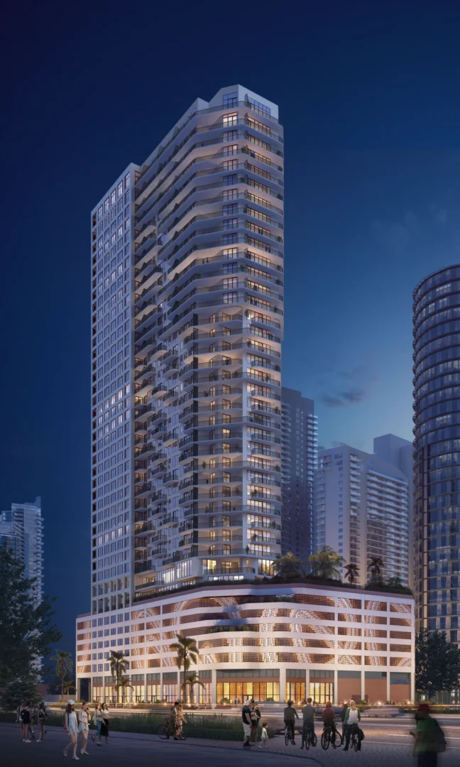 The illuminated high-rise building at 1775 Biscayne stands above pedestrians and cyclists on an urban street at night