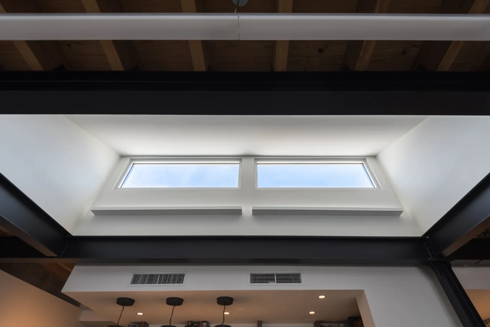 Two rectangular windows are framed by black steel beams in the ODP Architecture & Design Headquarters