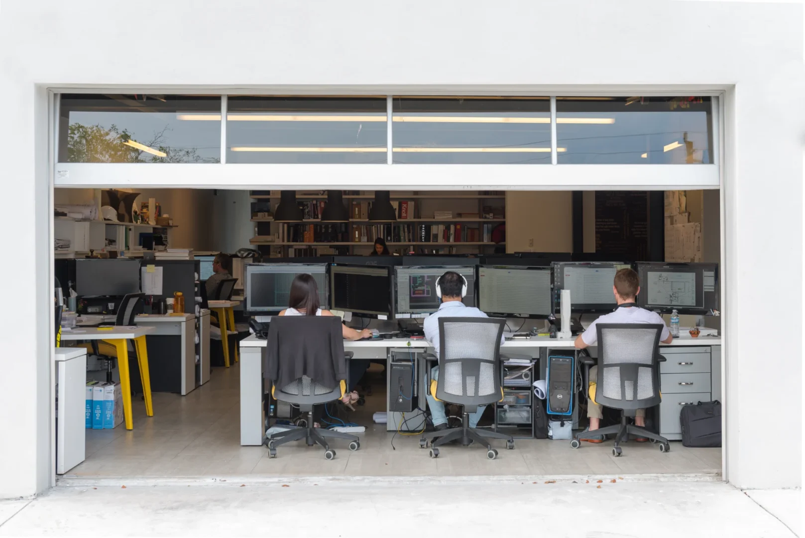 An open garage-style doorway reveals people working at computer workstations within the ODP Architecture & Design Headquarters