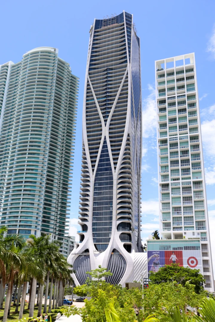 A tall, white-patterned skyscraper stands among other high-rise buildings near Sky Harbor Miami – Opa Locka Executive Airport