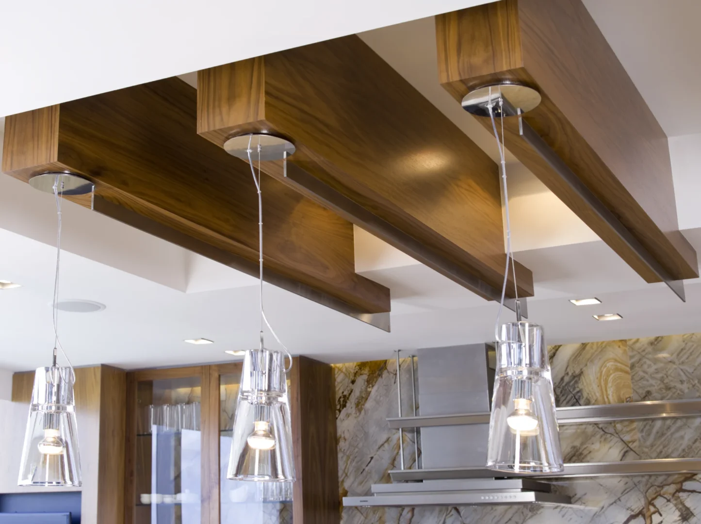 La cocina del ático 3 cuenta con grandes vigas de madera en el techo y lámparas colgantes de cristal.