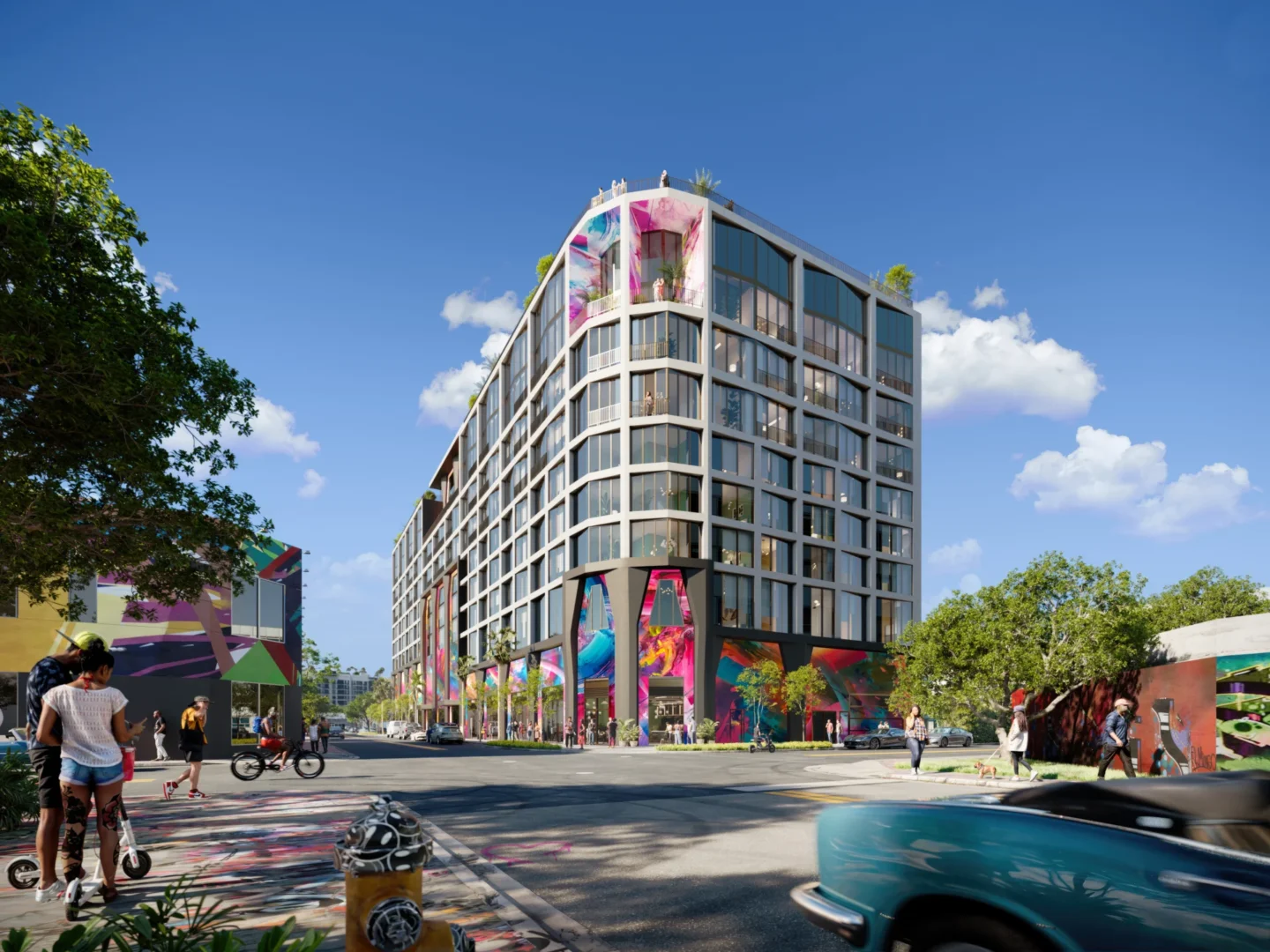 Un edificio de varias plantas del complejo The Cloud One Hotel & Residences Wynwood cuenta con amplios ventanales y coloridos murales cerca de una calle llena de gente.