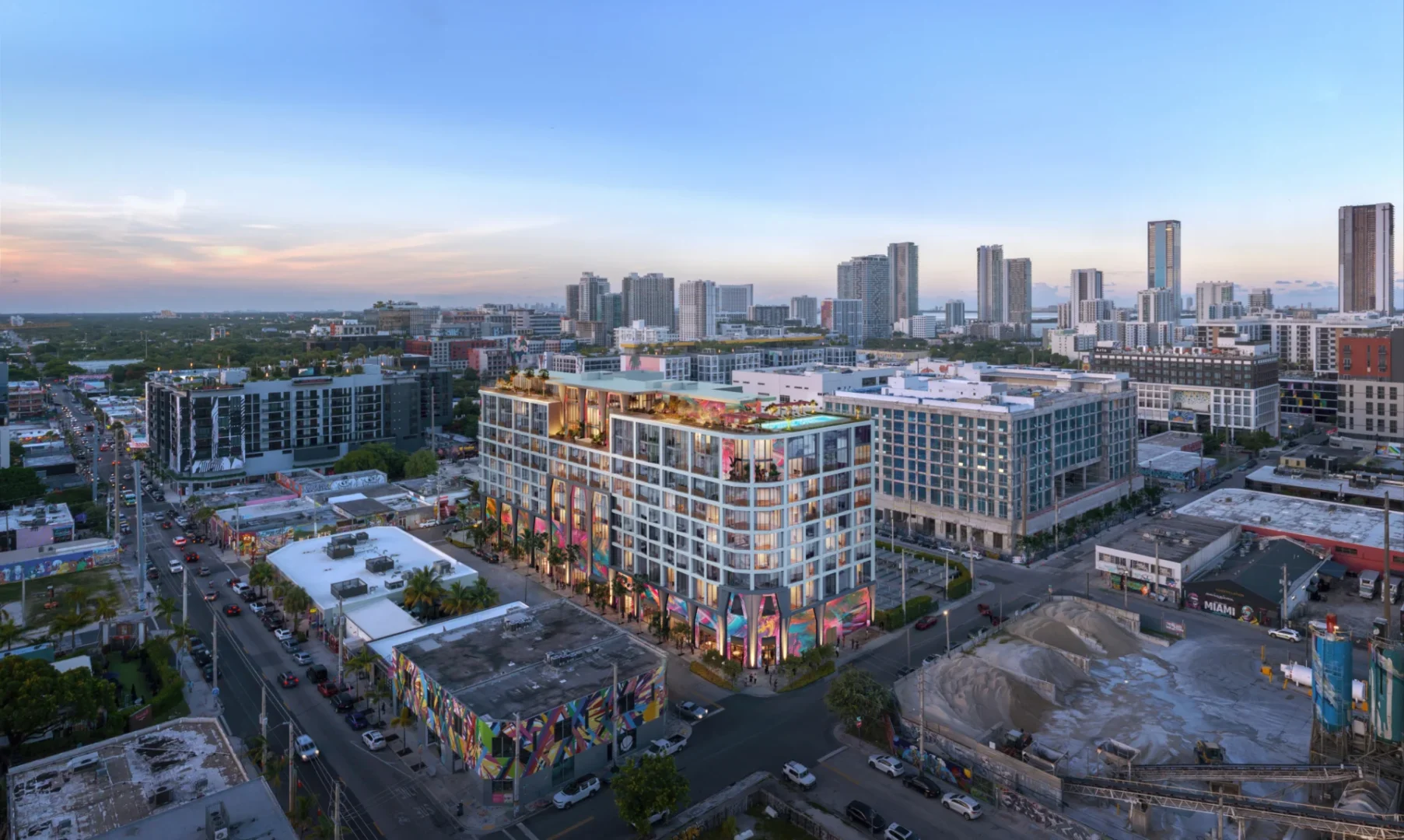 Un edificio de varias plantas con balcones acristalados y coloridos murales a pie de calle forma parte del complejo The Cloud One Hotel & Residences Wynwood.