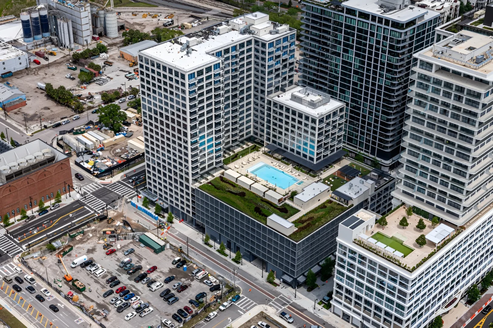 Los edificios de gran altura, entre los que se encuentra el Asher Water Street de Tampa, cuentan con una piscina en la azotea y una terraza con vistas a las calles, los coches y los silos industriales.