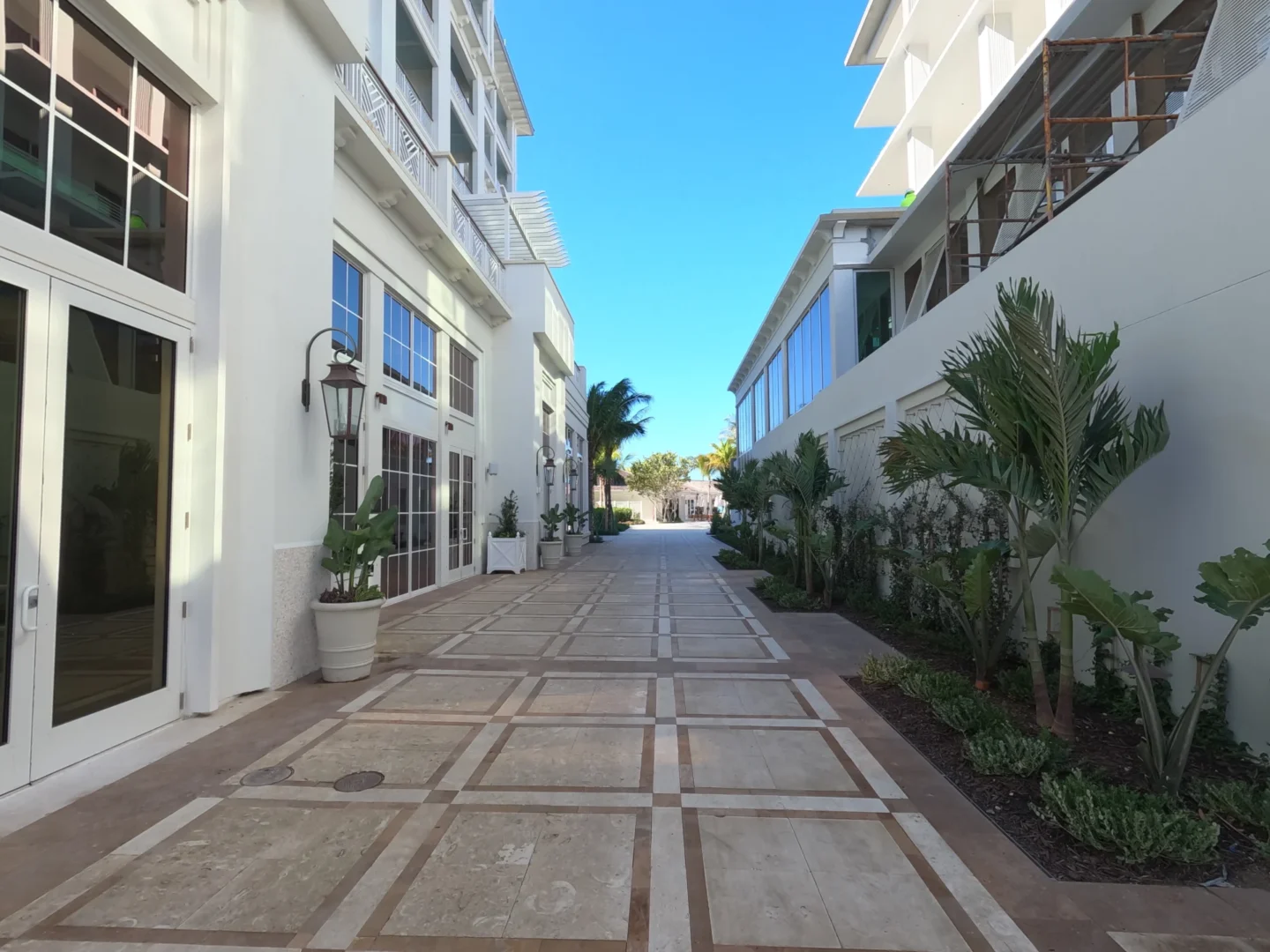 Un camino empedrado discurre entre los edificios blancos y las plantas del Four Seasons Resort & Residences de Naples Beach.
